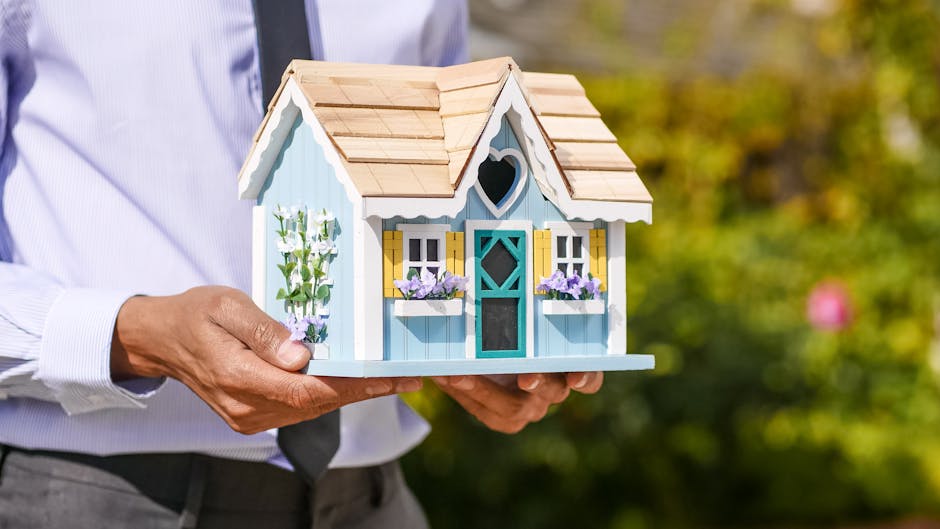 Close-up of a person holding a decorative miniature house outdoors